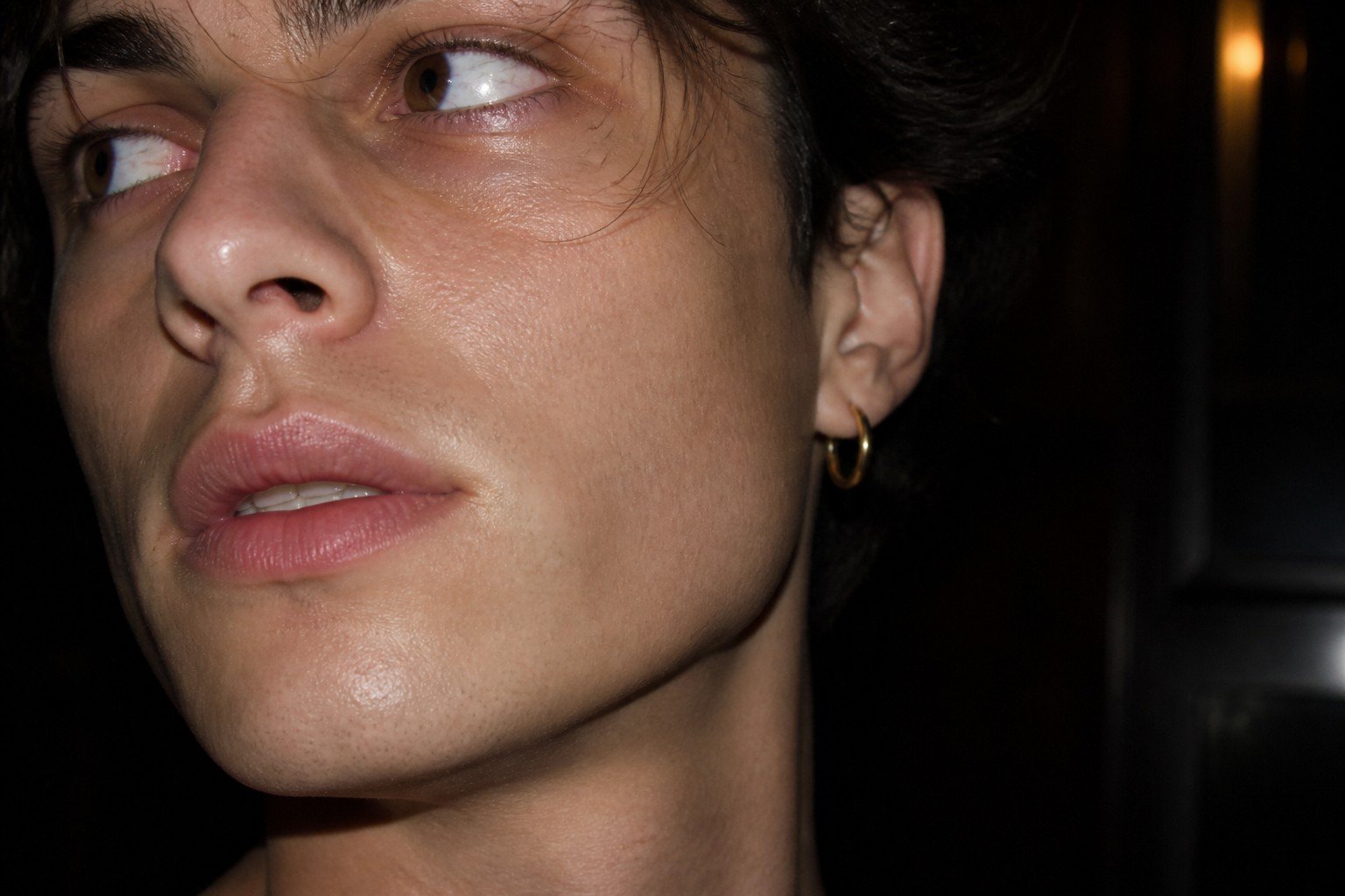 Retrato de perfil de un joven con pendiente, luz cálida
